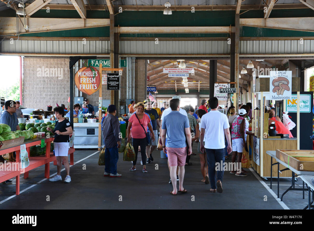 Les clients à pied l'allée principale au marché de producteurs de la Caroline du Nord à Raleigh. Banque D'Images Les clients à pied l'allée principale au marché de producteurs de la Caroline du Nord à Raleigh. Banque D'Images