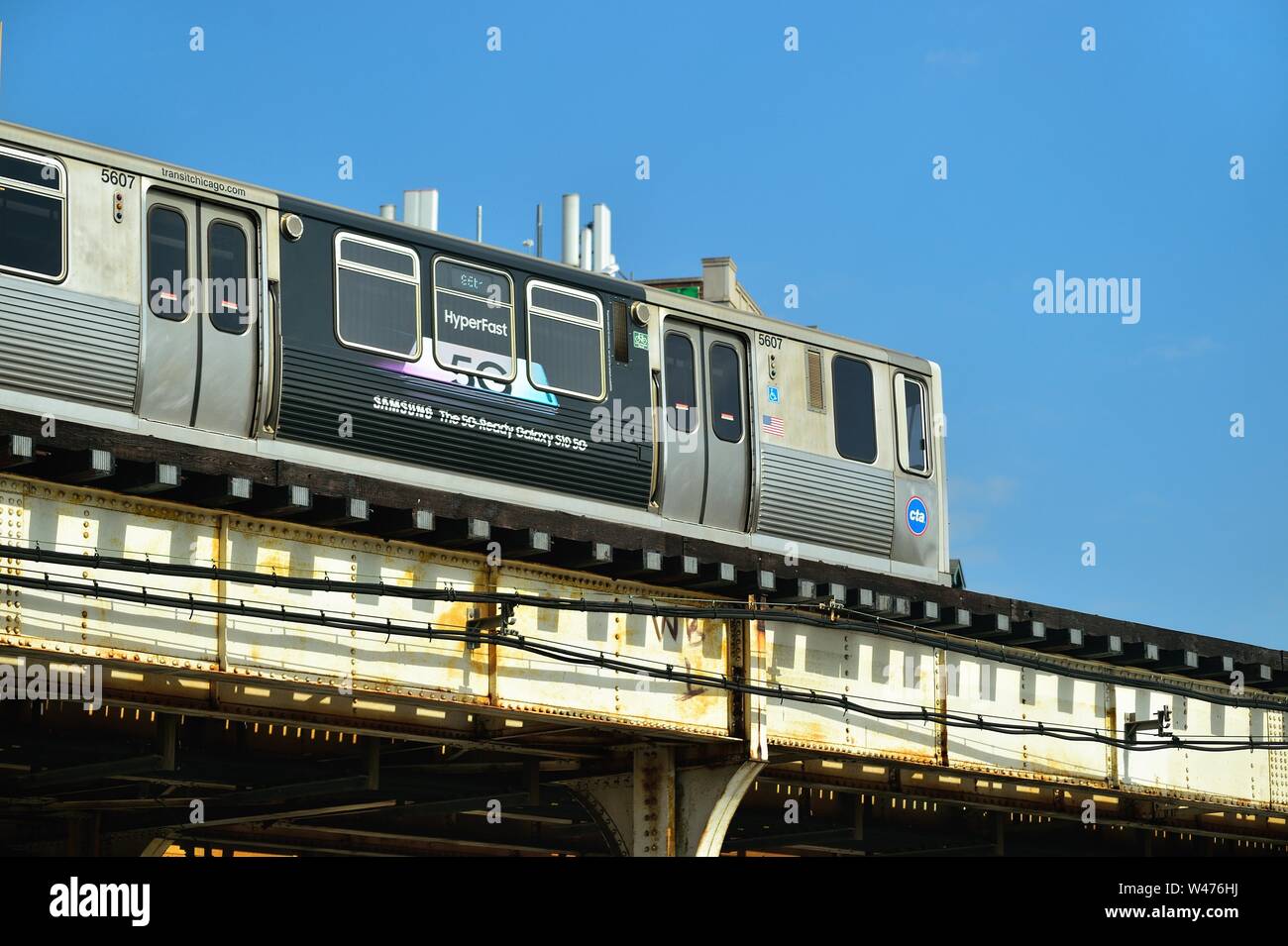 Chicago, Illinois, USA. Un CTA ligne rouge du train ornée avec la publicité traverse sur Clark Street à Chicago's Lakeview quartier. Banque D'Images