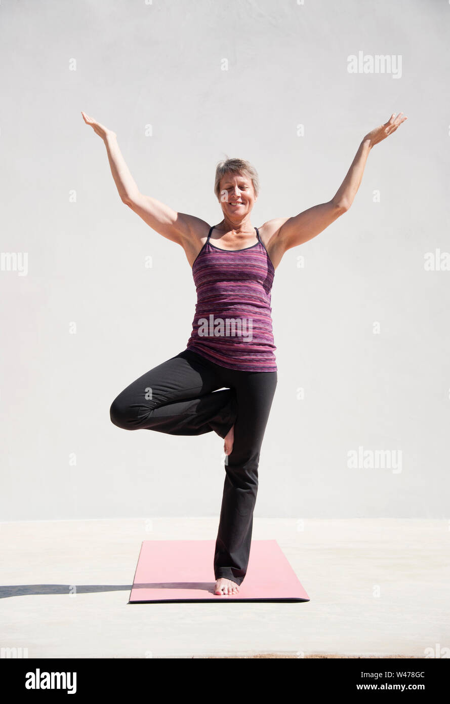 Practing mature woman gentle restorative yoga pose photographiés dans un fond blanc. Banque D'Images