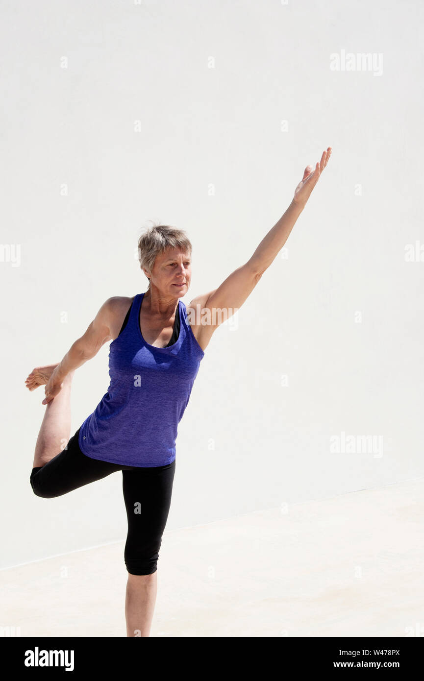 Practing mature woman gentle restorative yoga pose photographiés dans un fond blanc. Banque D'Images