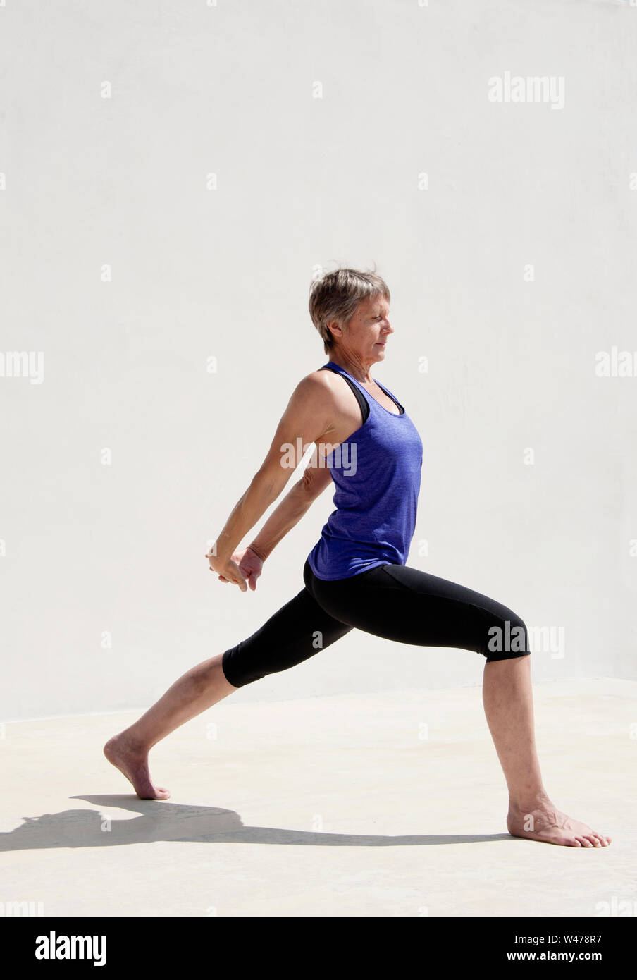 Practing mature woman gentle restorative yoga pose photographiés dans un fond blanc. Banque D'Images