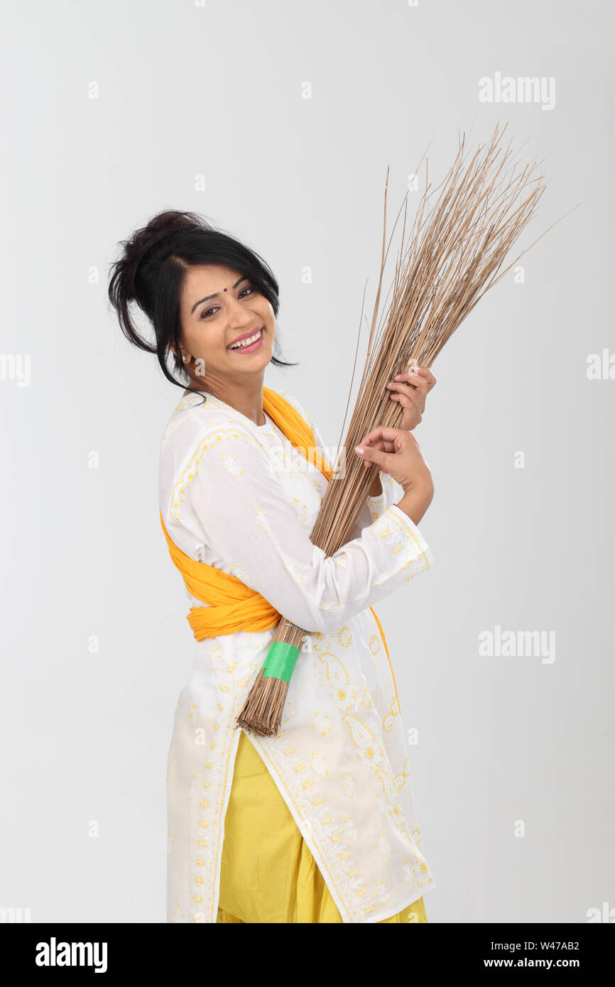 Femme prétendant jouer de la guitare avec un balai Banque D'Images