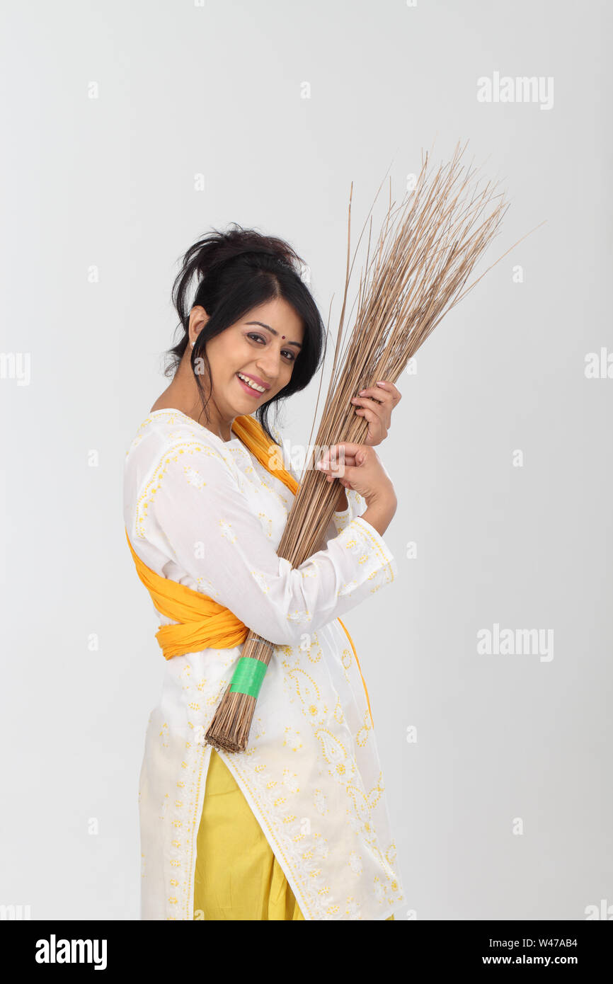 Femme prétendant jouer de la guitare avec un balai Banque D'Images