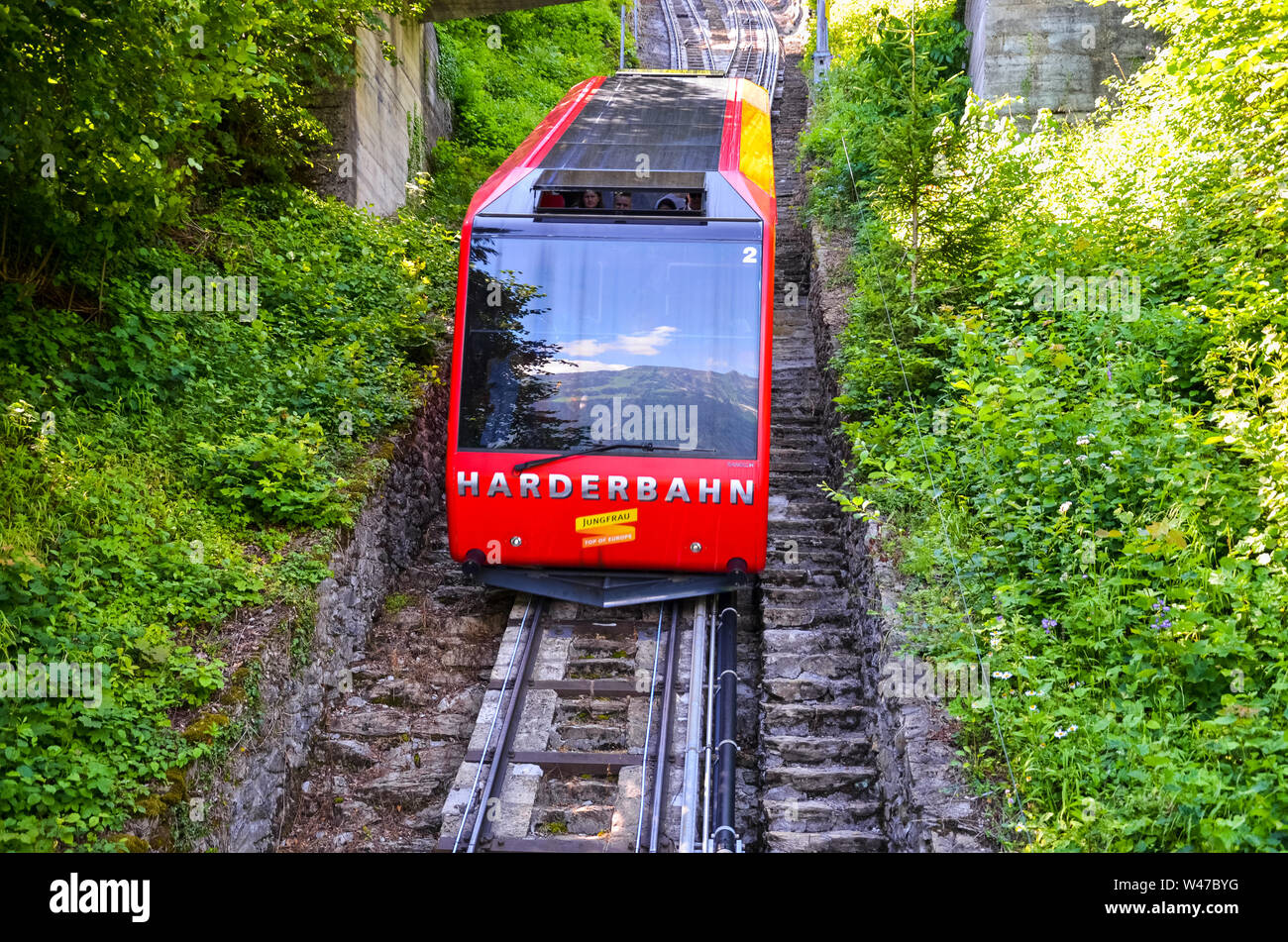 Interlaken, Suisse - le 16 juillet 2019 : téléphérique rouge en descente de Kulm, plus haut de Interlaken. Les lecteurs de funiculaire de touristes en haut et en bas du point de vue populaire. Le transport, le tourisme. Banque D'Images