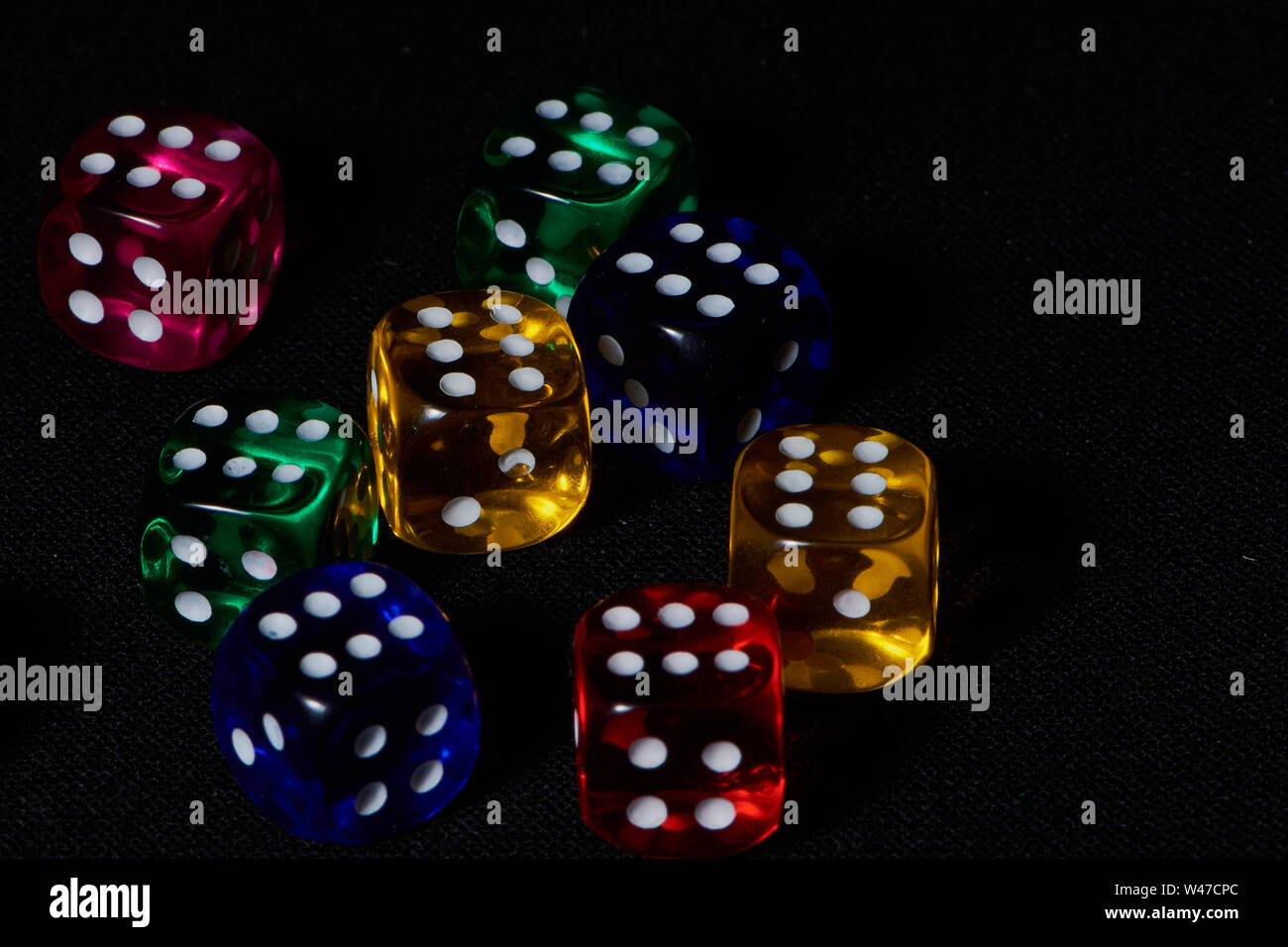 Macro de huit dés de couleur avec le chiffre 6 sur fond noir Banque D'Images