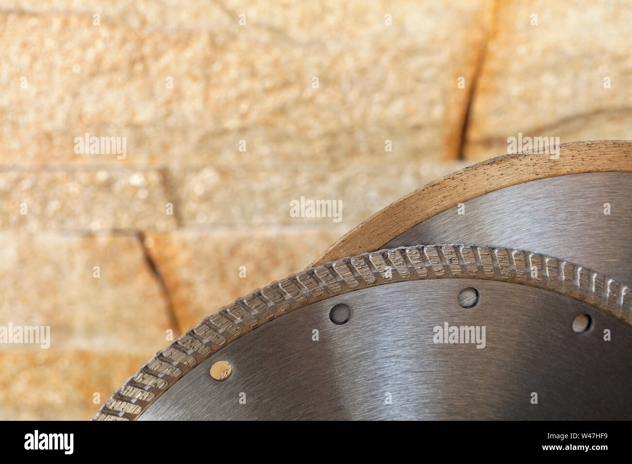 Disques de coupe en argent de segment dans le contexte d'un mur de grès doré à l'orange en gros plan. Banque D'Images