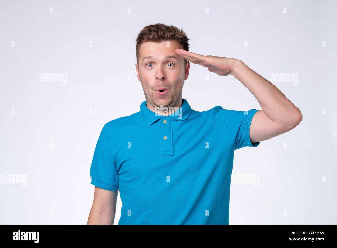 Bel homme européen en bleu shirt saluting Banque D'Images