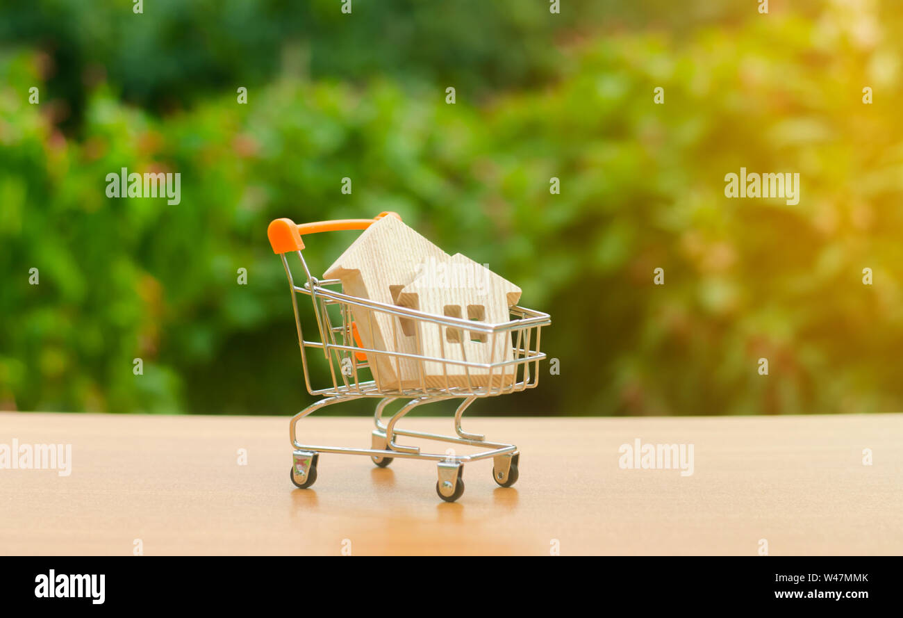 Deux maisons en bois dans un panier d'échange sur la nature. Investissement attrayant. la hausse des prix. L'offre et de la demande, les prix de ventes. Le concept d'adhésion Banque D'Images