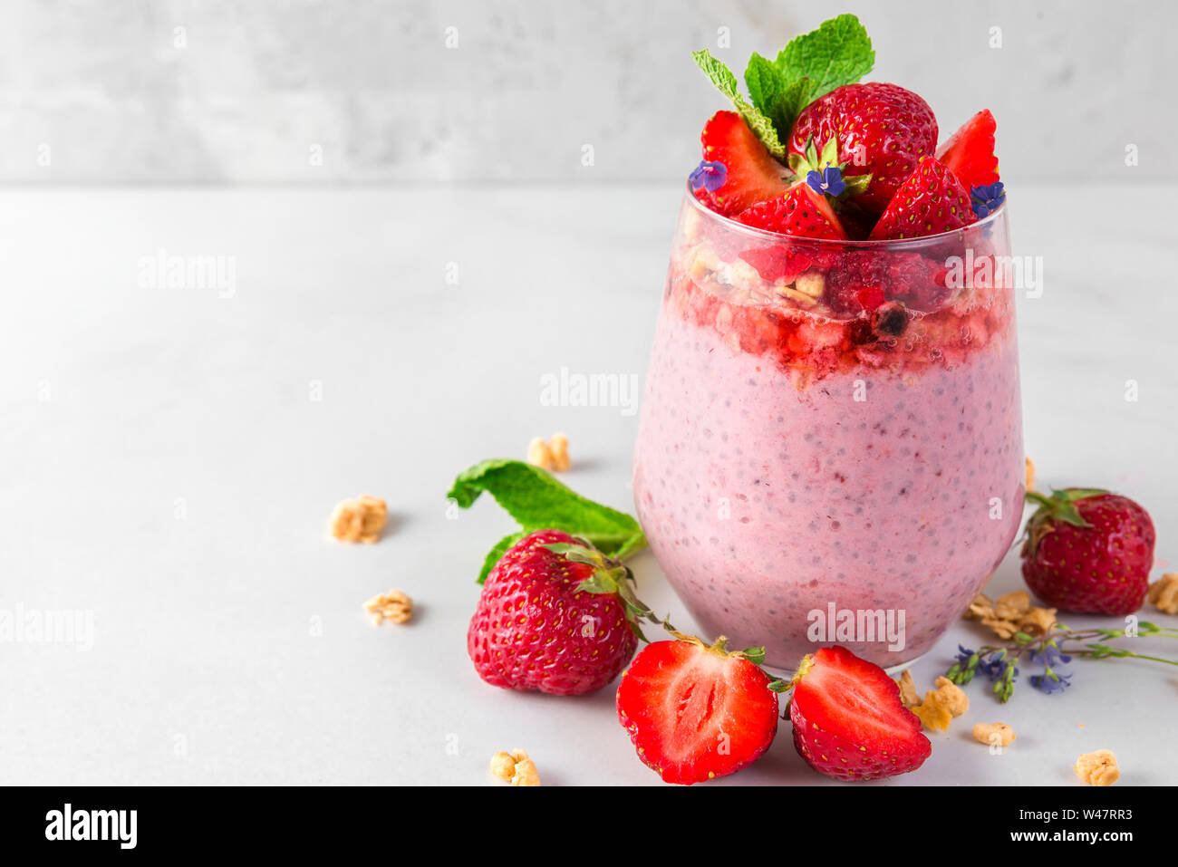 Délicieux petit déjeuner sain. dessert yogourt aux fraises ou semences chia pudding avec granola, les baies fraîches et menthe. close up Banque D'Images