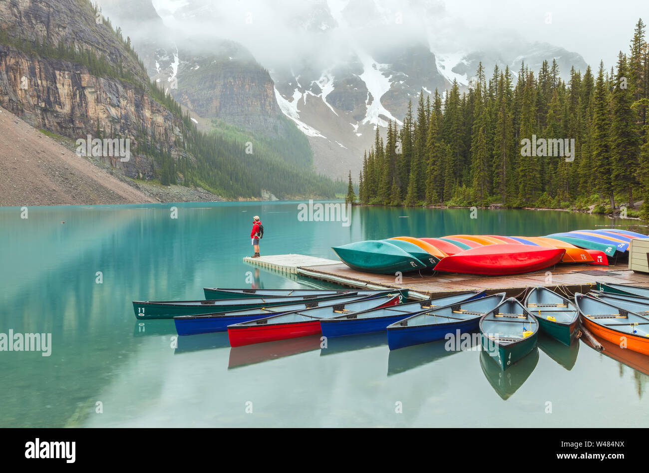 Les canots et colorés un visiteur au lac Moraine, parc national Banff, Canada, sur un matin de pluie Banque D'Images