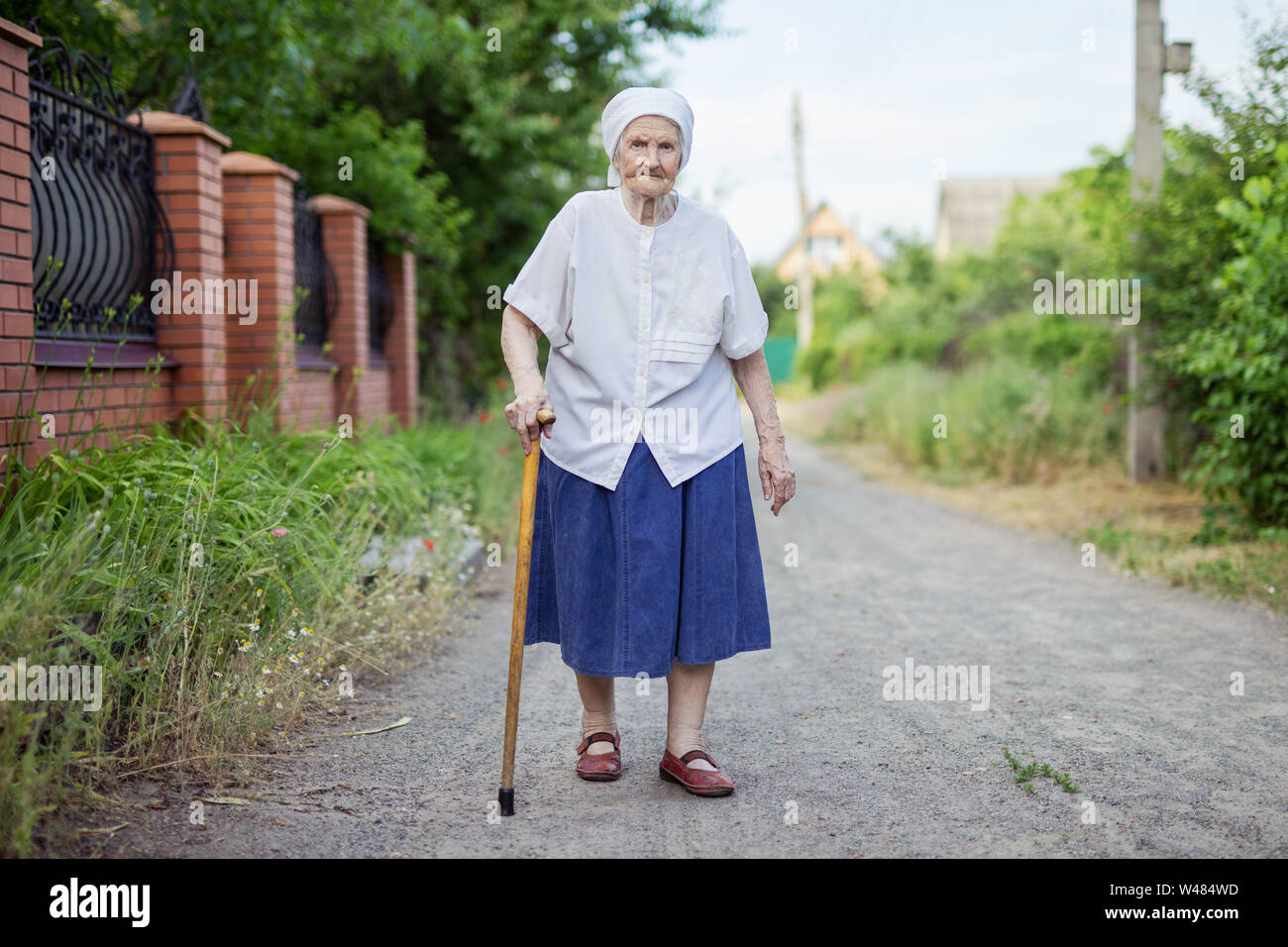 Portrait of senior woman walking down street in countryside Banque D'Images