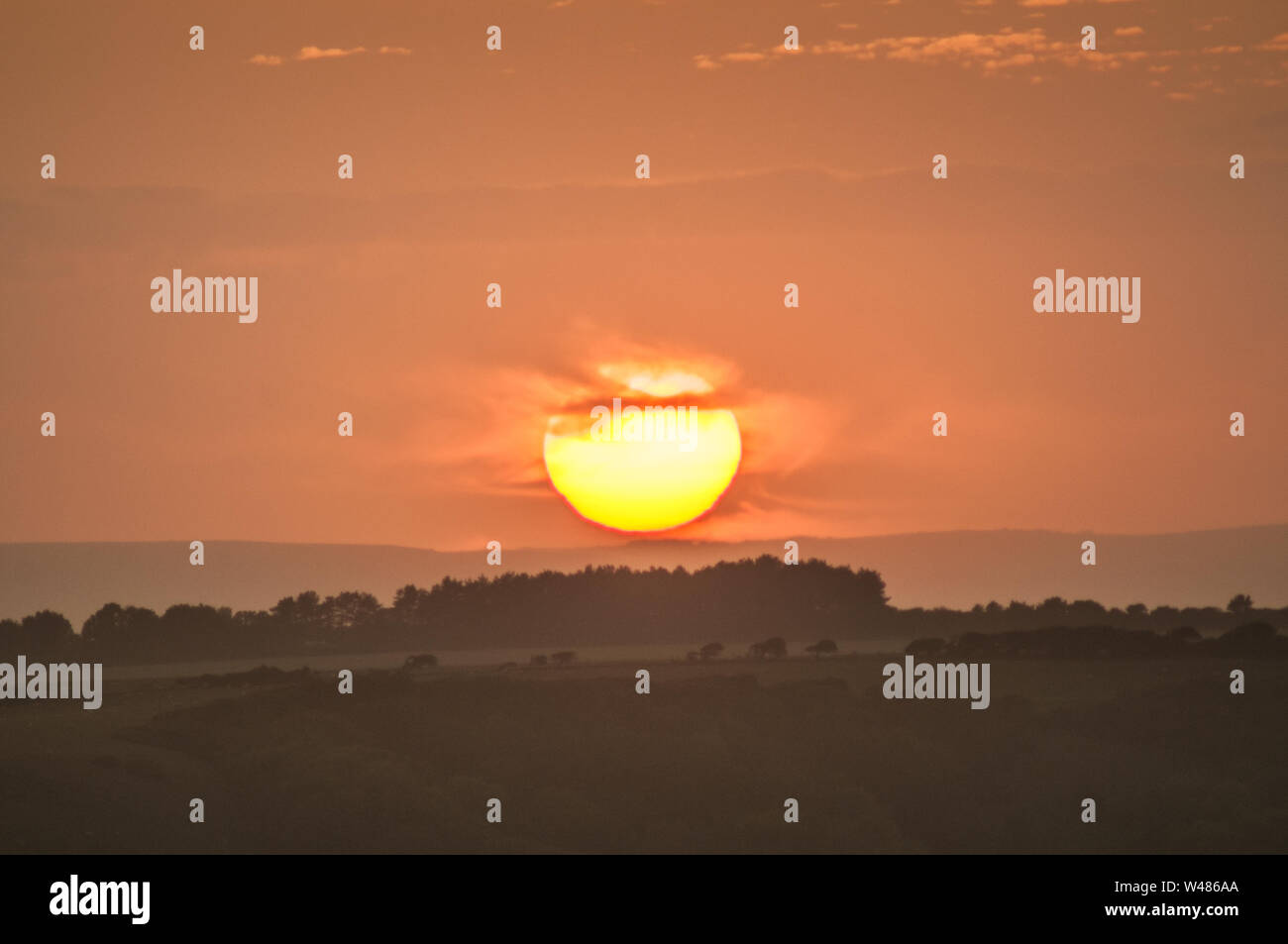 Eastbourne, East Sussex, Royaume-Uni. 20 juillet 2019..Superbe séquence de coucher de soleil sur la campagne brumeuse alors que Sun se couche derrière le nuage pour réapparaître quelques minutes plus tard à l'horizon. Deux couchers de soleil en une journée. . Banque D'Images