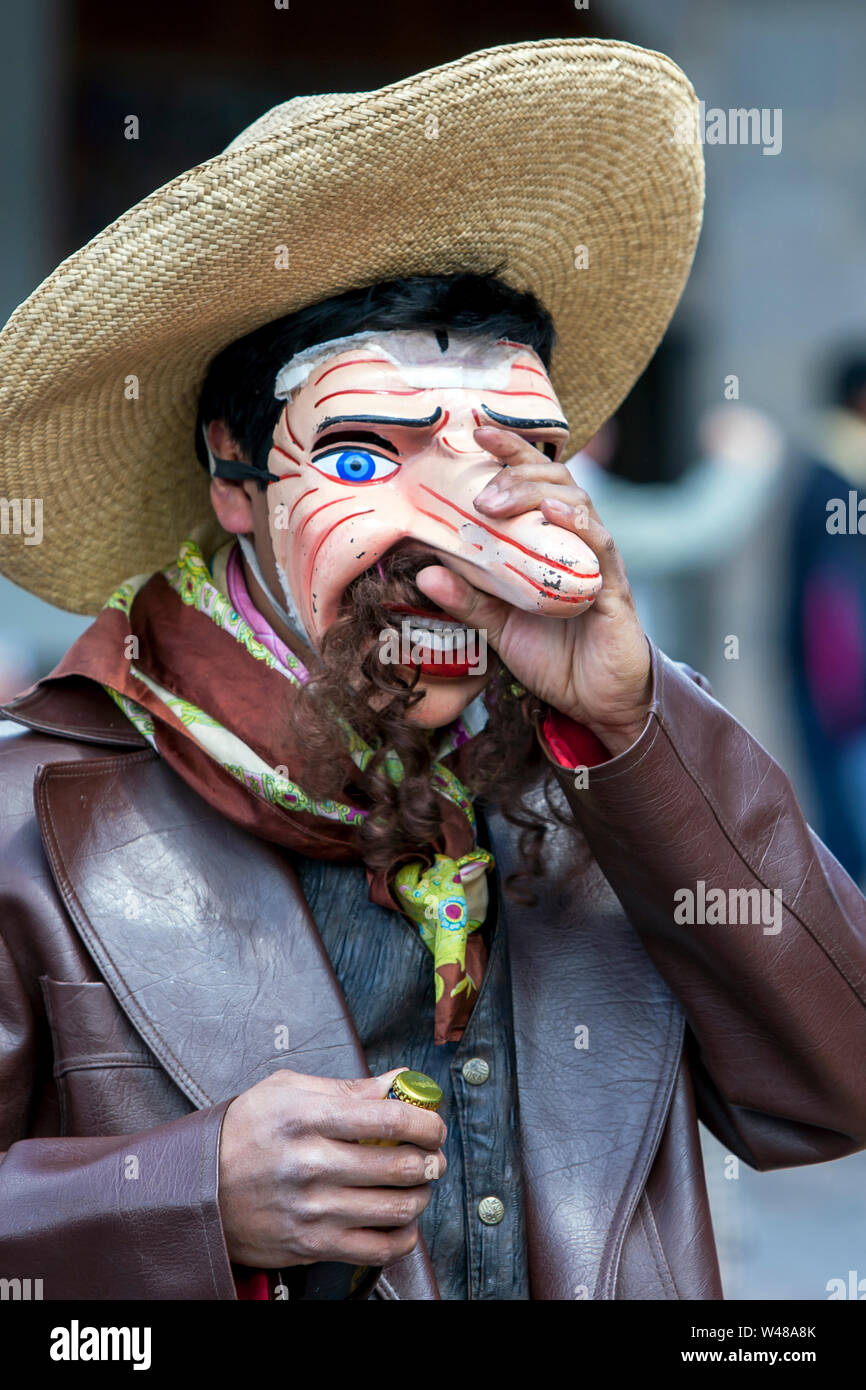 Un homme habillé en costume péruvien doté d''un masque de visage avec de grands nez fonctionne à Plaza de Armas de Cusco au Pérou en mai, au cours de la Day Parade. Banque D'Images
