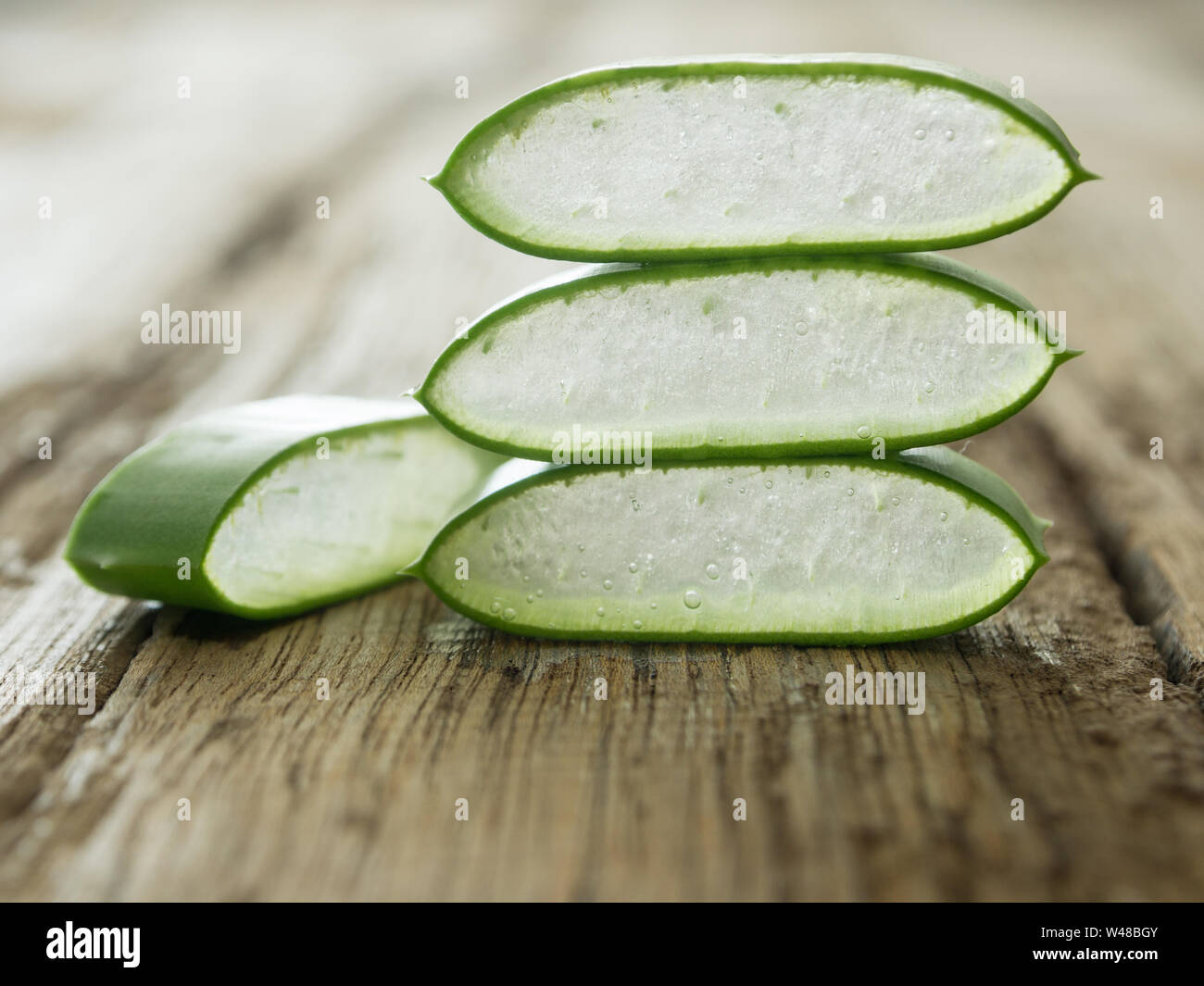 L'aloe vera placer les morceaux sur une table de bois. soft focus Banque D'Images