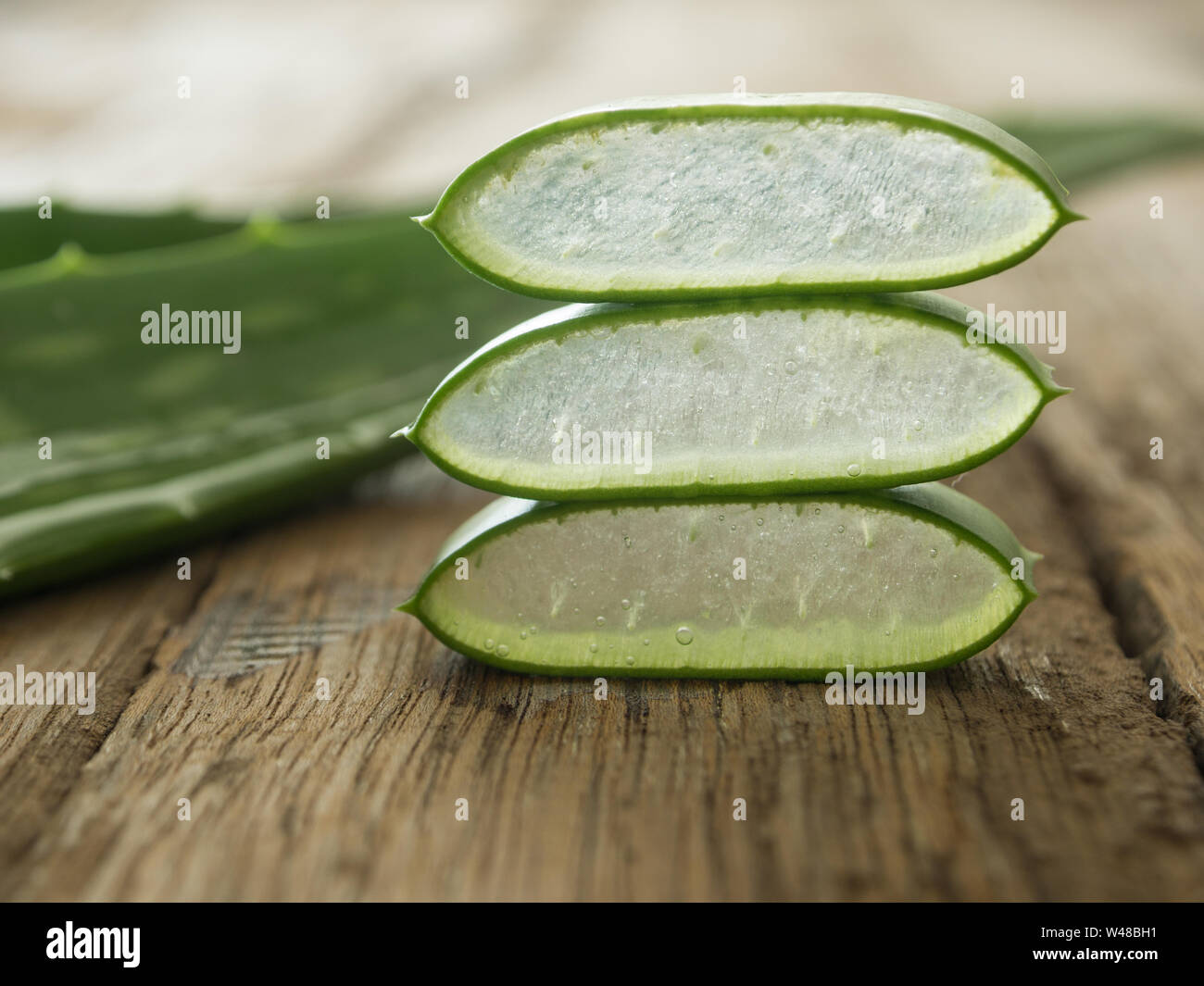 L'aloe vera placer les morceaux sur une table de bois. soft focus Banque D'Images