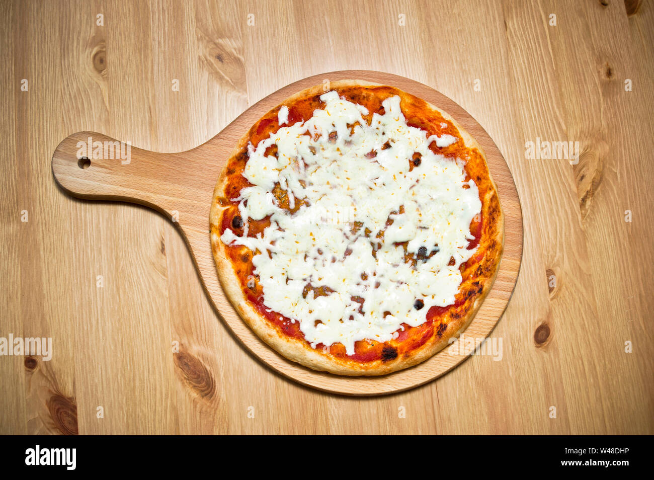Pizza Margherita juste notre du four sur une table ronde en bois plateau de service Banque D'Images Pizza Margherita juste notre du four sur une table ronde en bois plateau de service Banque D'Images