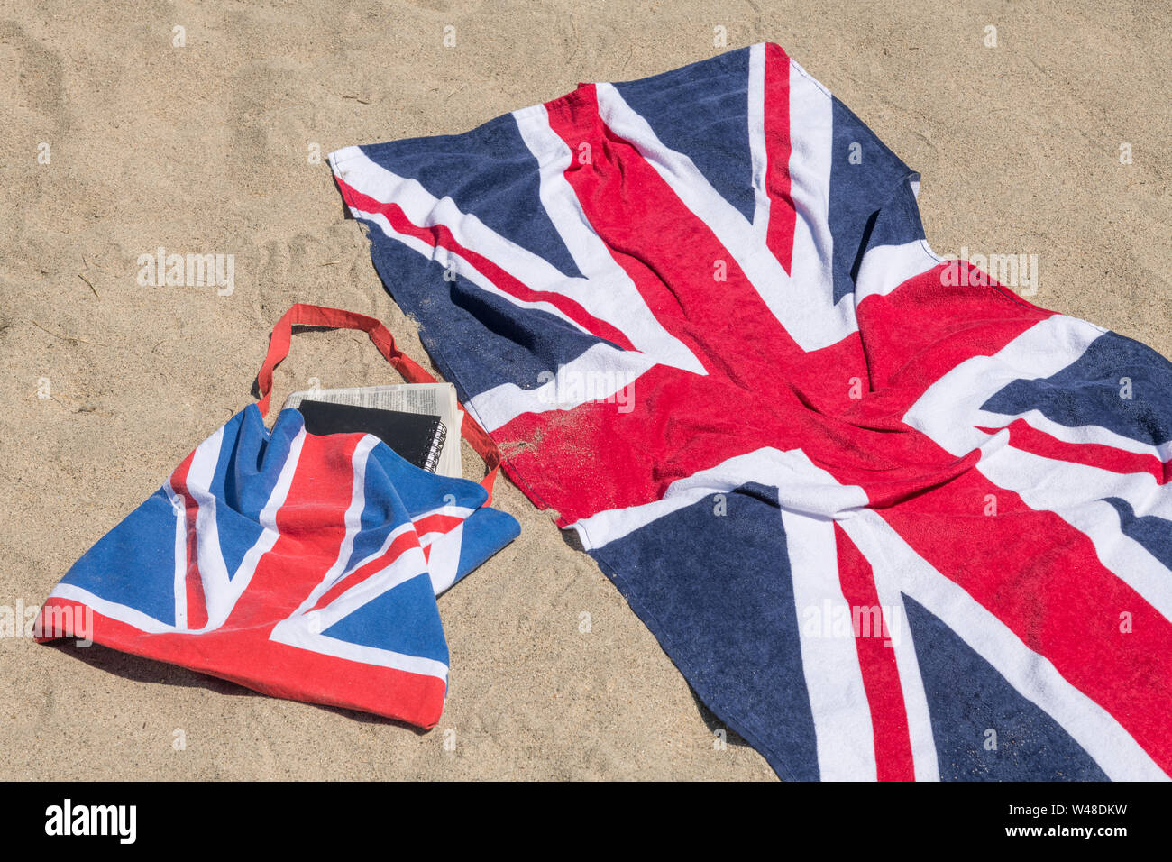 Serviette de plage et sac de plage Union Jack sur une plage de sable. Pour 2021 vacances au Royaume-Uni, vacances à la maison, vacances en Cornouailles, vacances en bord de mer, serviette Union Jack. Banque D'Images