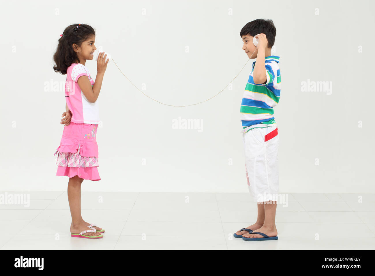 Indian girl et un garçon jouant avec une boîte en fer-phone Banque D'Images