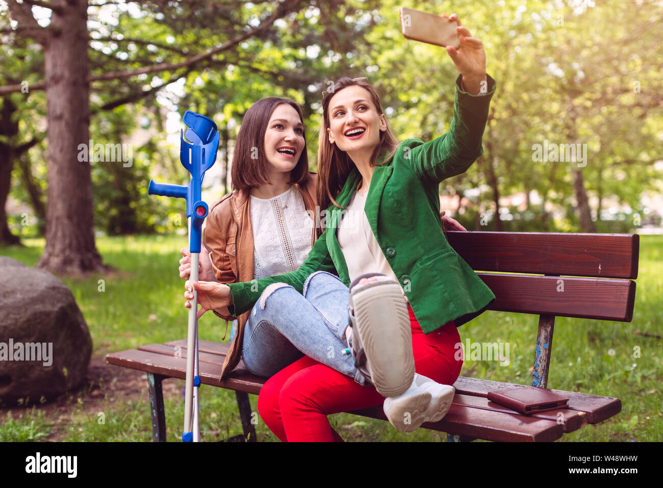 Femme et son ami avec une entorse à la cheville de la prise d'une photo Banque D'Images