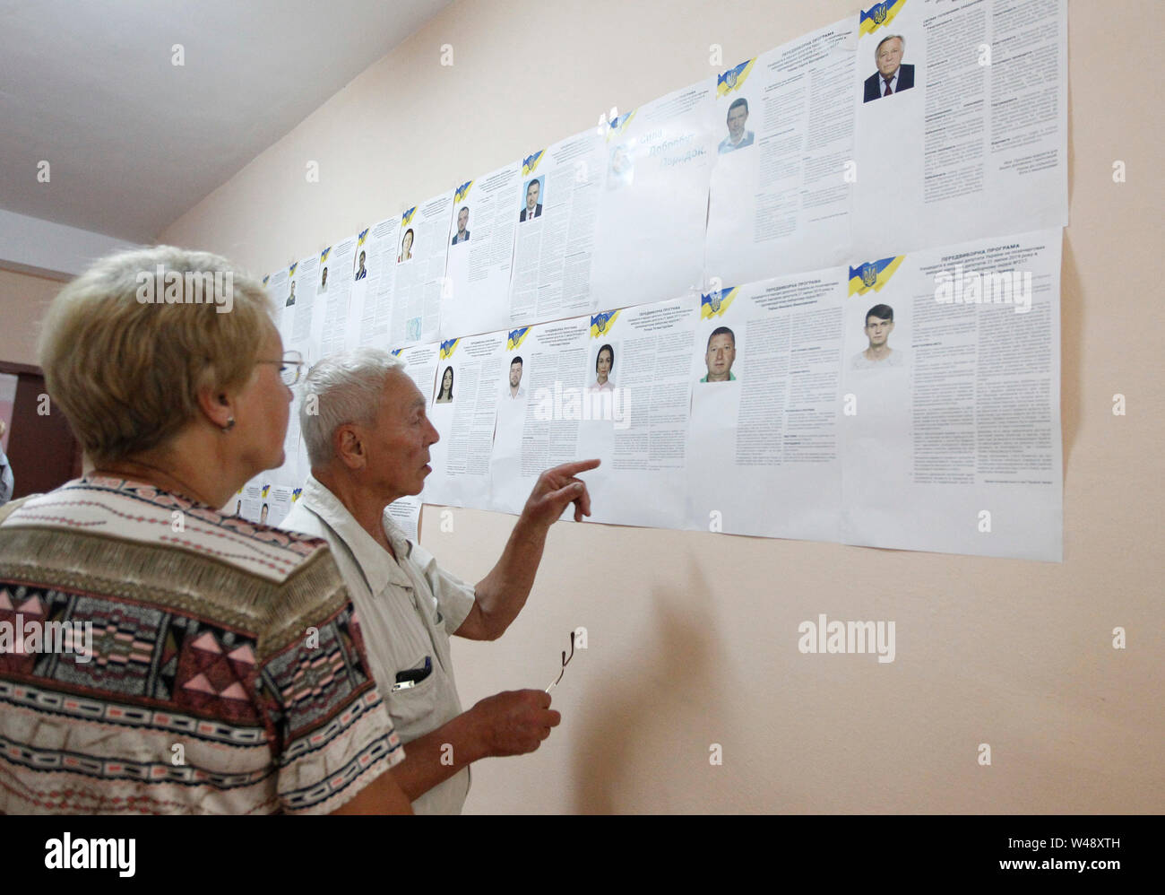 Les électeurs d'examiner un épinglé liste des candidats au bureau de scrutin durant les élections parlementaires.Des élections anticipées au parlement ukrainien aura lieu le 21 juillet 2019. Qui devait avoir lieu à la fin du mois d'octobre, ces élections ont été mises de l'avant après nouvellement inauguré Président Vladimir Zelensky dissous le parlement le 21 mai 2019, lors de son inauguration. Banque D'Images