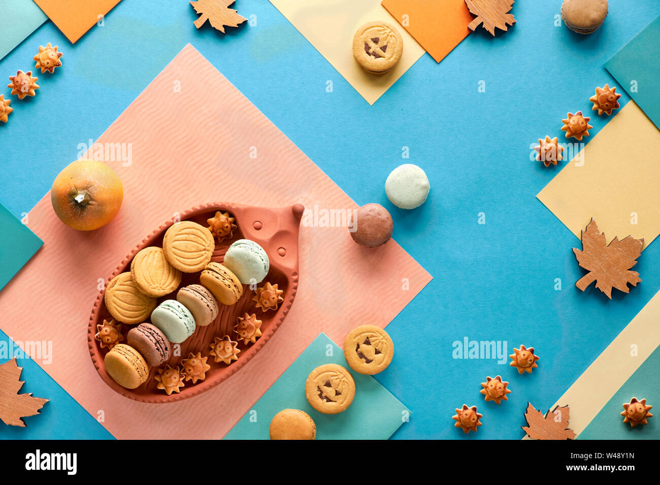 Automne fond géométrique, le papier à plat avec les cookies d'Halloween, les macarons et les décorations saisonnières Banque D'Images
