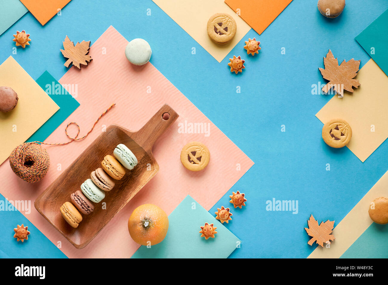 Automne fond géométrique, le papier à plat avec les cookies d'Halloween, les macarons et les décorations saisonnières Banque D'Images