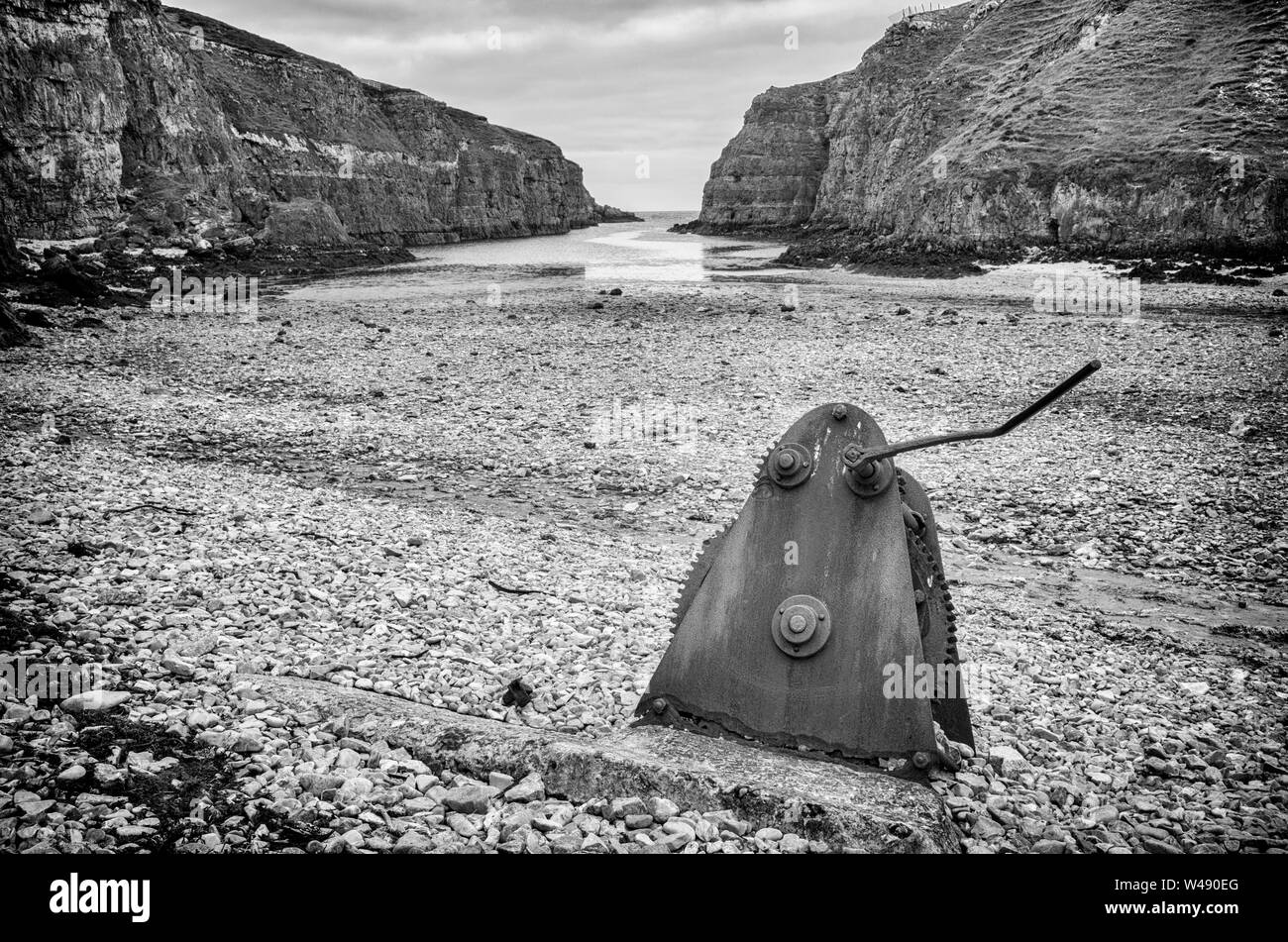 Rusty, un morceau de machiney abandonnés qui a engrenages, repose sur une plage rocheuse à Geodha à Smoo Cave Smoo, une grande cave et d'eau douce mer combiné cave Banque D'Images