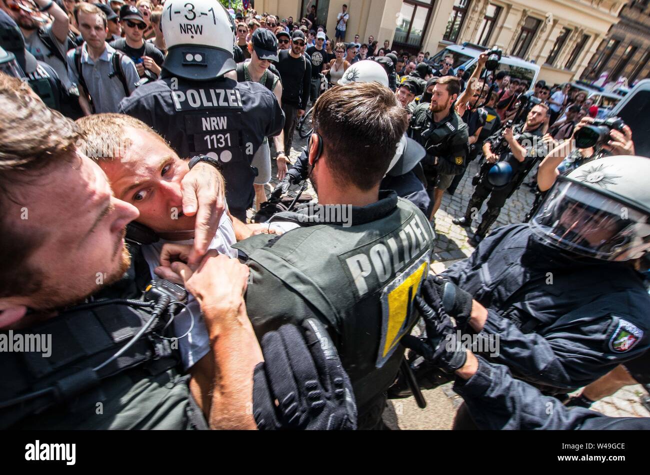 Saale, Sachsen Anhalt, Allemagne. 20 juillet, 2019. Un manifestant pacifique contre les extrémistes de droite de la suprématie blanche, Identiaere Bewegung (Génération de l'identité) à Halle an der Saale, Allemagne permet un contact visuel avec un agent de police qui a été interdisant à lui après qu'il et un autre officier sont tirés au sol par la police anti-émeute. Credit : Sachelle Babbar/ZUMA/Alamy Fil Live News Banque D'Images