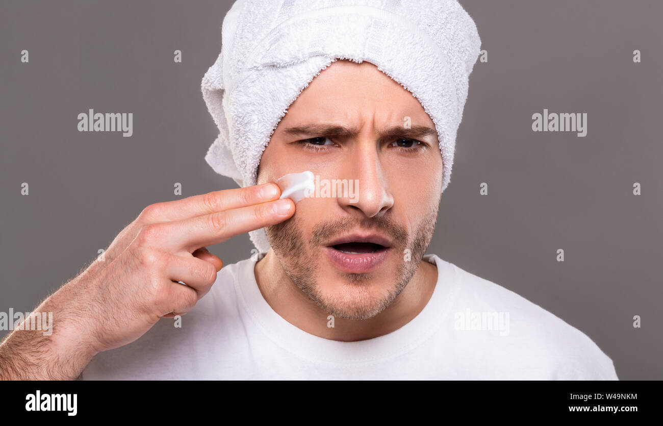 Bel homme de mettre de la crème sur ses joues comme warrior Banque D'Images