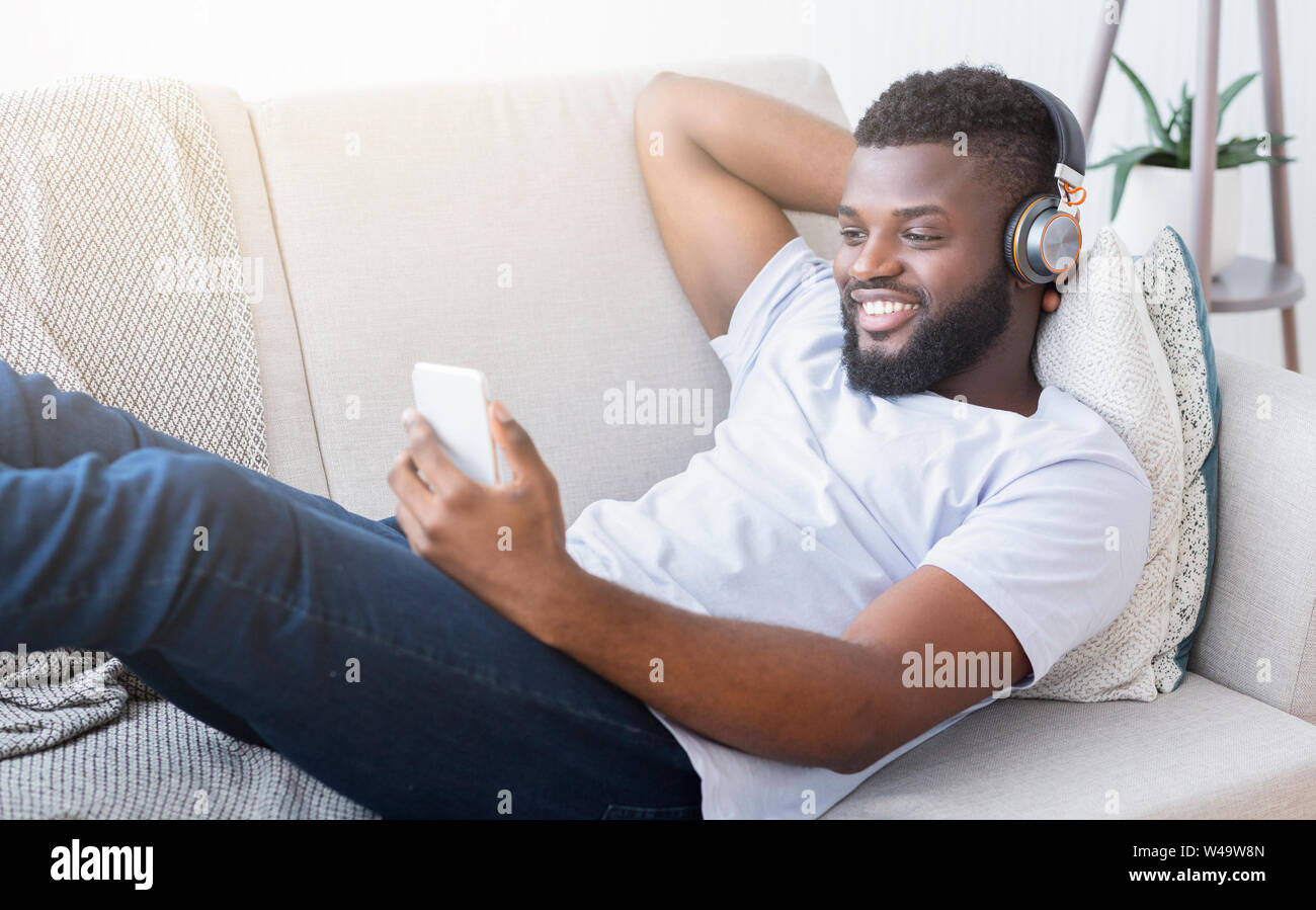 Casque homme noir à regarder la vidéo sur smartphone Banque D'Images