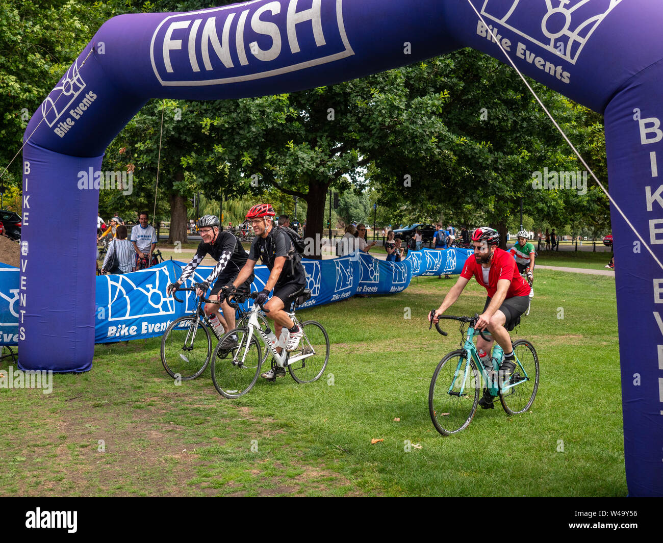 Cambridge, UK. 21, juillet 2019. Trois coureurs franchissent la ligne d'arrivée de Londres à Cambridge bike ride. L'itinéraire de la balade couvre environ 60 milles à partir de Pickett's Lock dans le nord de Londres et se terminant à Jesus Green au cœur de Cambridge. Crédit : Alex Skinner/Alamy live news Banque D'Images