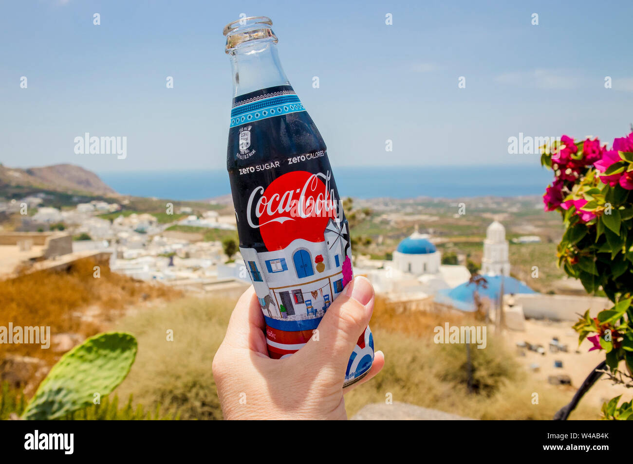 Santorin, Pyrgos /Grèce-15OCT2019. Main tenant custom made Coca Cola Zero bouteille avec l'île de Santorin photo thème spécial sur l'étiquette. Rare col Banque D'Images