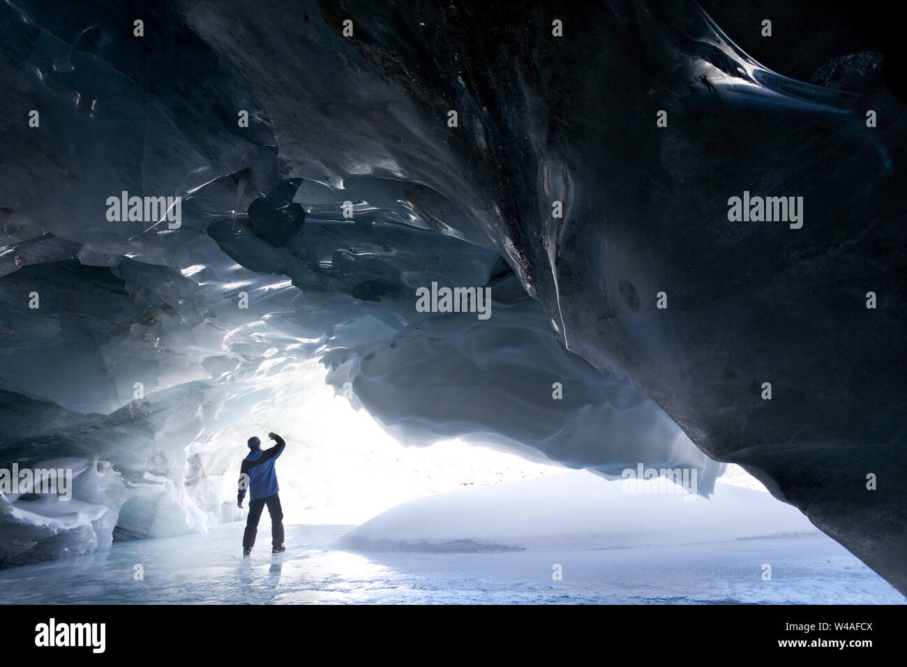 Explorez Une magnifique grotte de glace avec des formations de glace bleues naturelles en hiver. Banque D'Images
