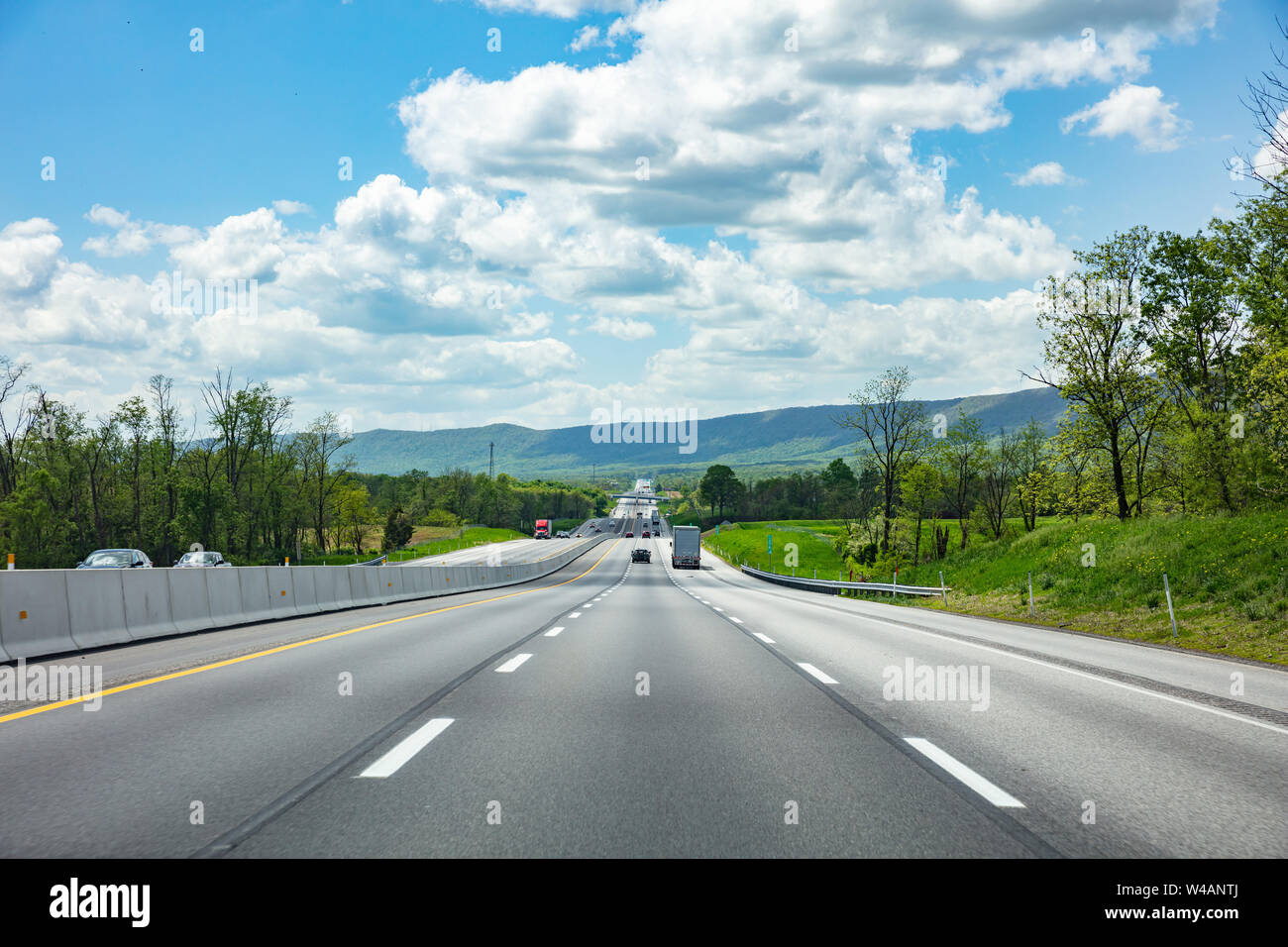 L'autoroute dans une journée de printemps ensoleillée, USA. Route nationale, en passant par la campagne américaine. Fond de Ciel bleu nuageux Banque D'Images