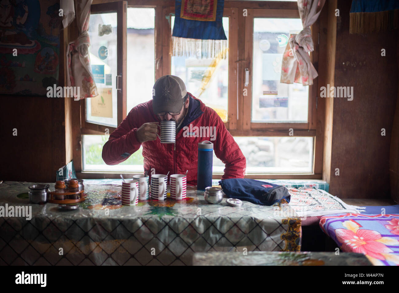 Man drinking tea in village ville en montagnes de l'himalaya Banque D'Images