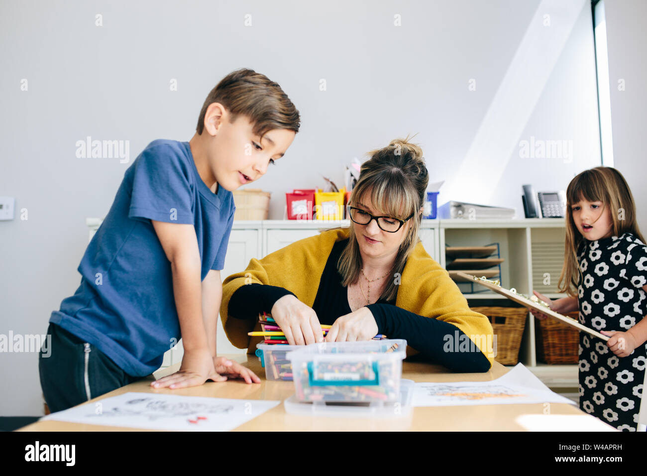 Sortes d'enseignants grâce à des crayons de couleur, tandis que les étudiants se préparent à travailler Banque D'Images