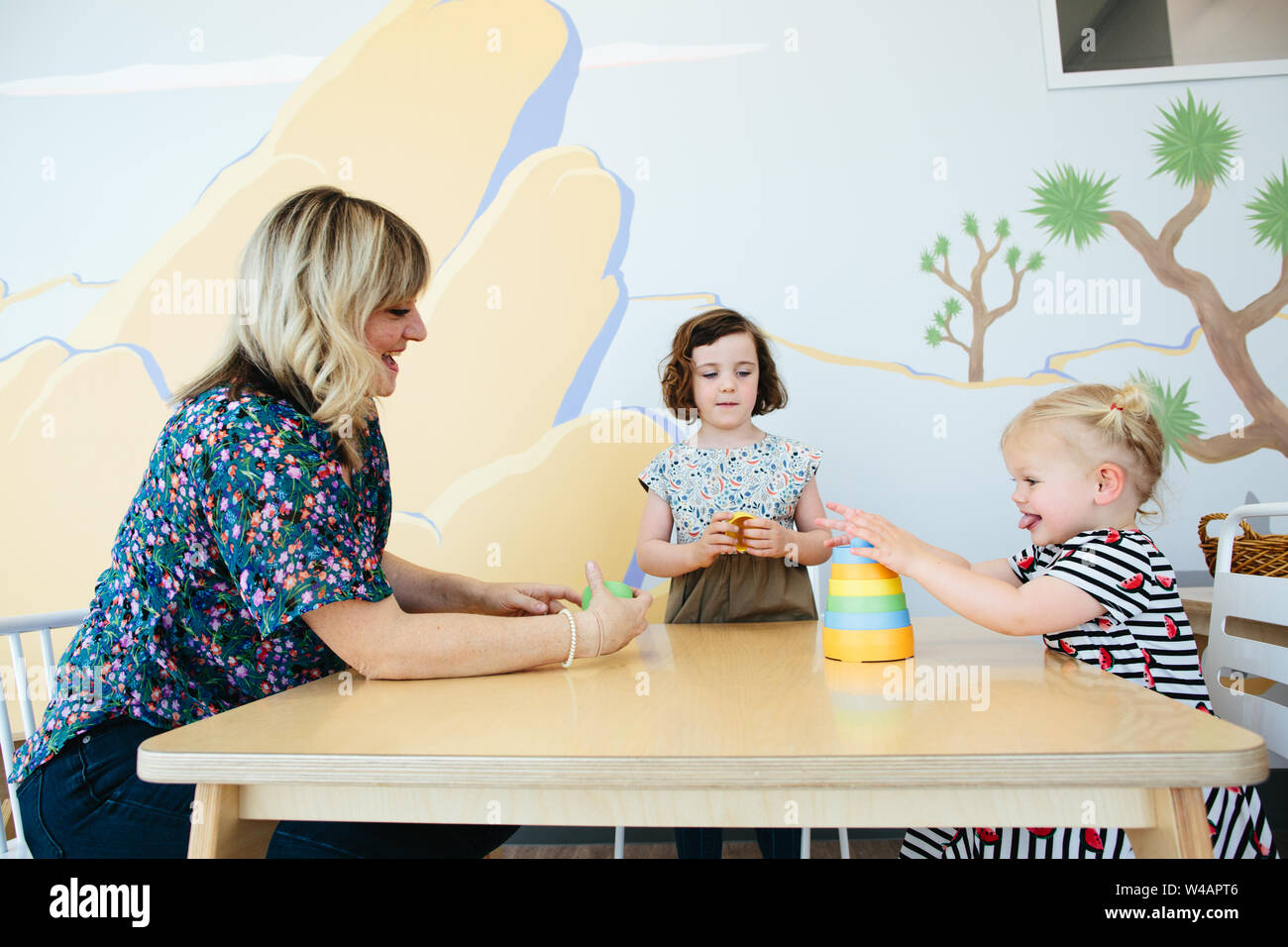 Bébé fille en langue maternelle en triomphe sur son jouet d'empilage Banque D'Images