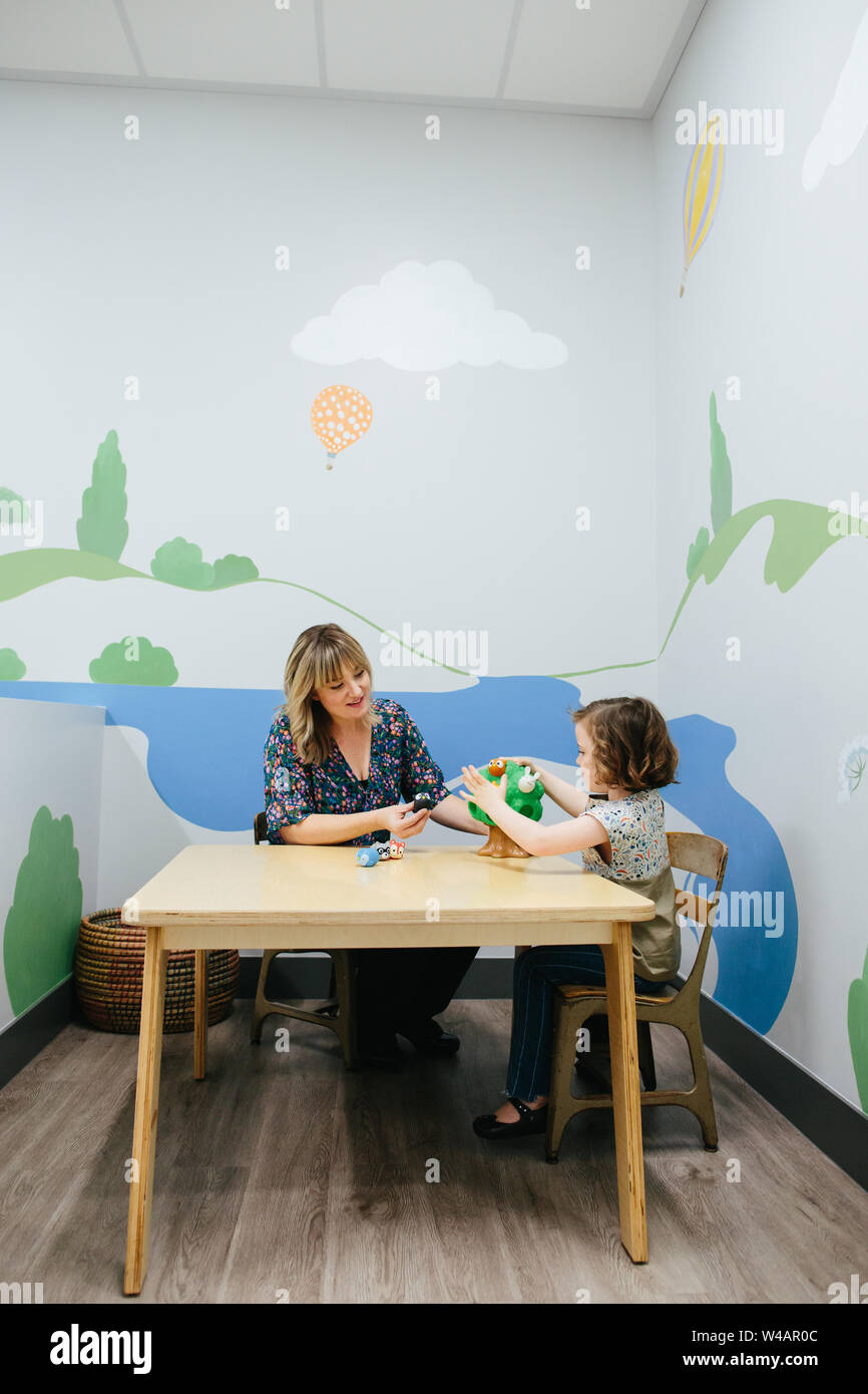 Le professeur et l'étudiant s'asseoir à table et travailler ensemble à jouer avec un jouet Banque D'Images