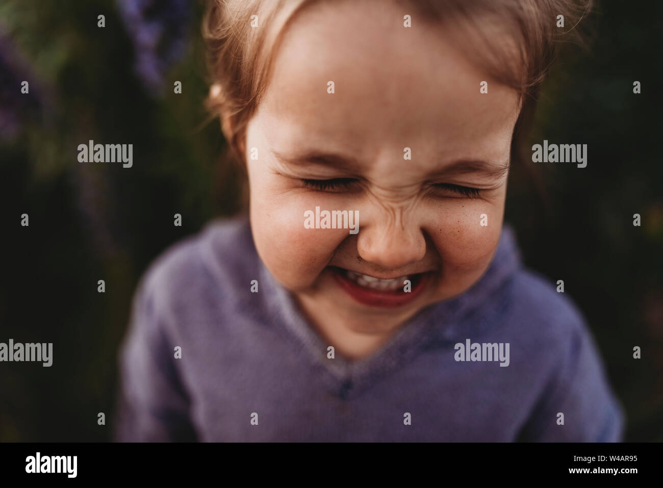 Close up portrait of little girl nez scrunching et rire Banque D'Images