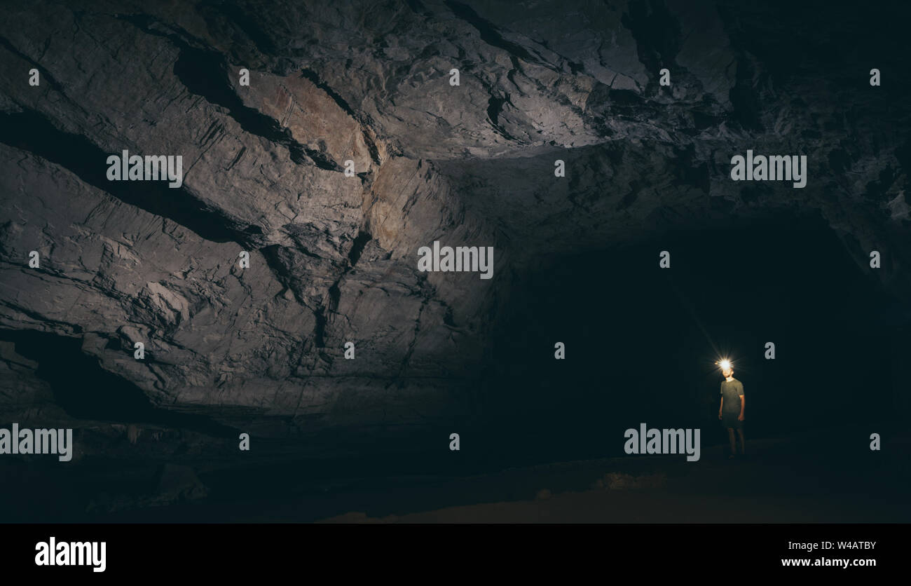 Les droits de l'ossature est à l'intérieur de la grotte de l'eau avec une torche dans la main en Konglor, Laos. Banque D'Images