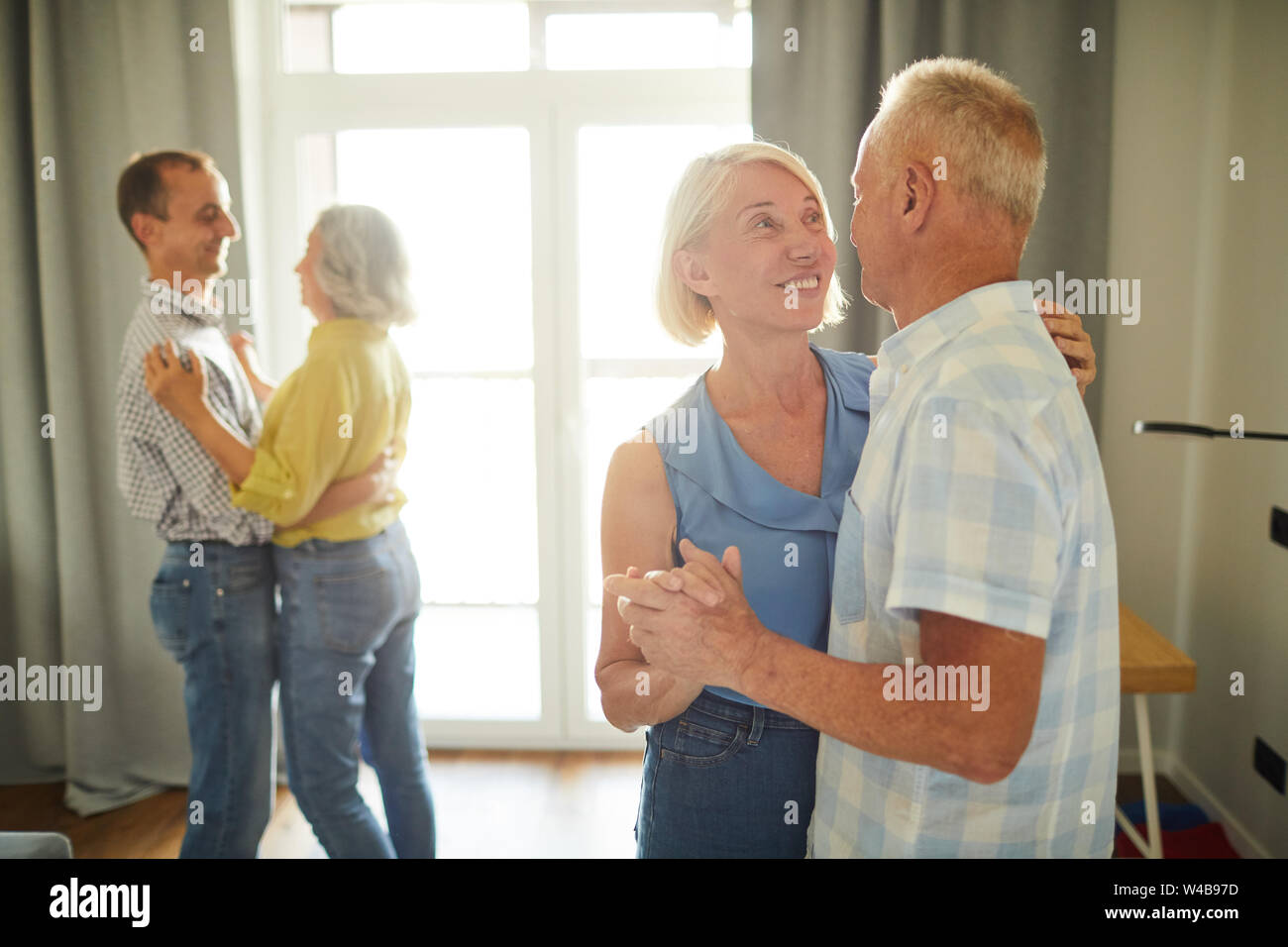 Portrait de deux senior couples dancing romantiquement pendant party à la maison, copy space Banque D'Images