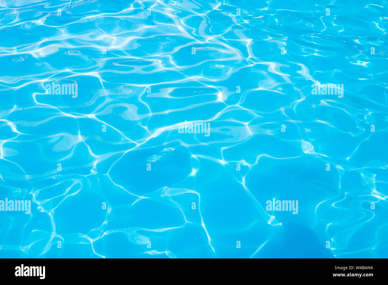 Piscine d'eau de la texture et de l'eau de surface extérieure. Belle bleue avec fond de l'eau reflets du soleil. Banque D'Images