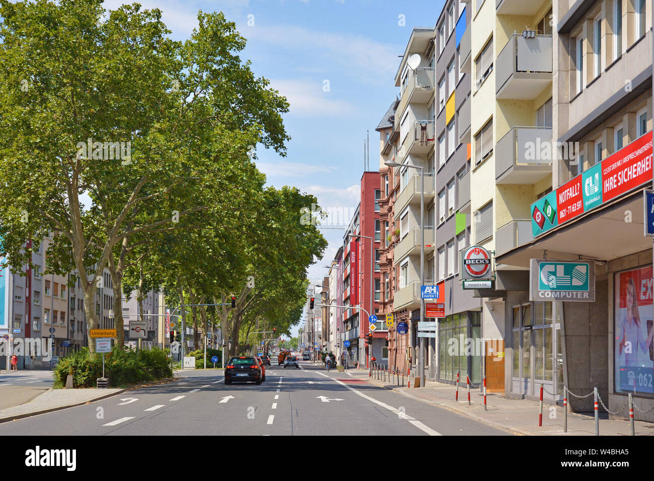 Mannheim, Allemagne, Juillet 2019 : Road et le côté rue avec les voitures et les petits magasins en ville de Mannheim Banque D'Images