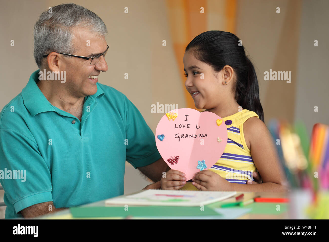 Fille montrant un message 'Je t'aime' à son grand-père Banque D'Images