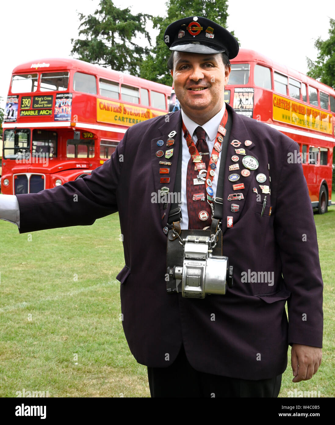 Conducteur de bus traditionnels qui posent avec une collection d'insignes de l'axe. Banque D'Images