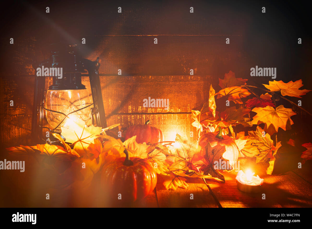 Bougie lanterne citrouille Halloween avec des feuilles sèches de l'automne sur sol en bois décorer sur fond d'halloween holiday avec effet filter Banque D'Images