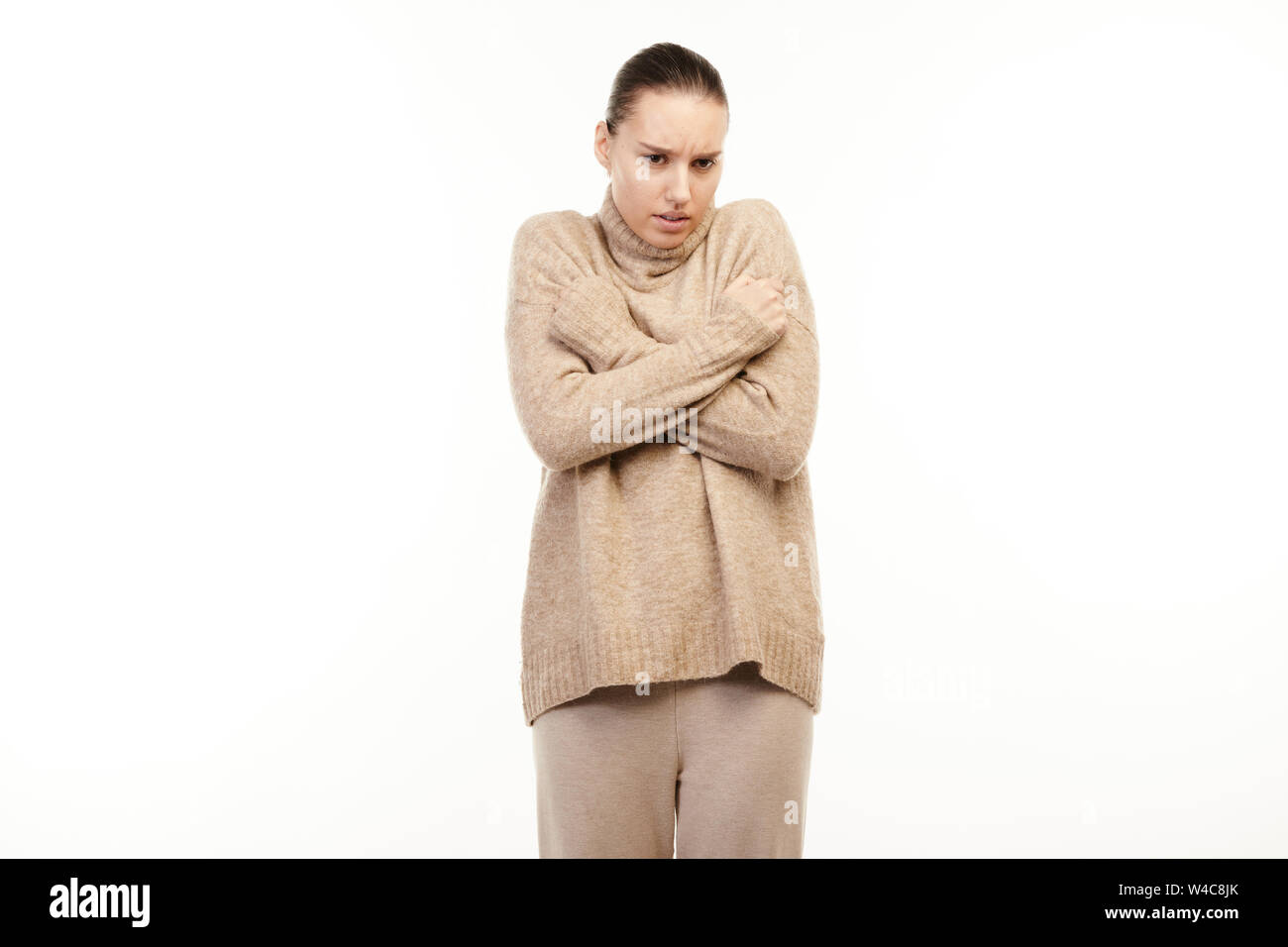 Femme malade a des frissons et tente de se réchauffer. Banque D'Images