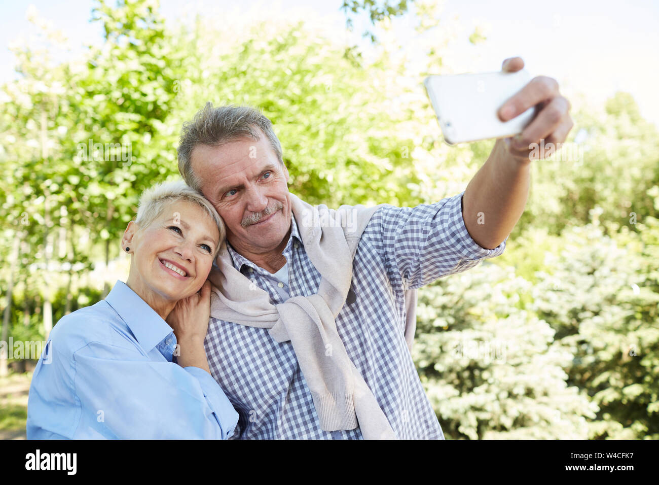 Taille portrait de senior couple pose pour photo selfies tout en profitant de promenade en forêt, copy space Banque D'Images