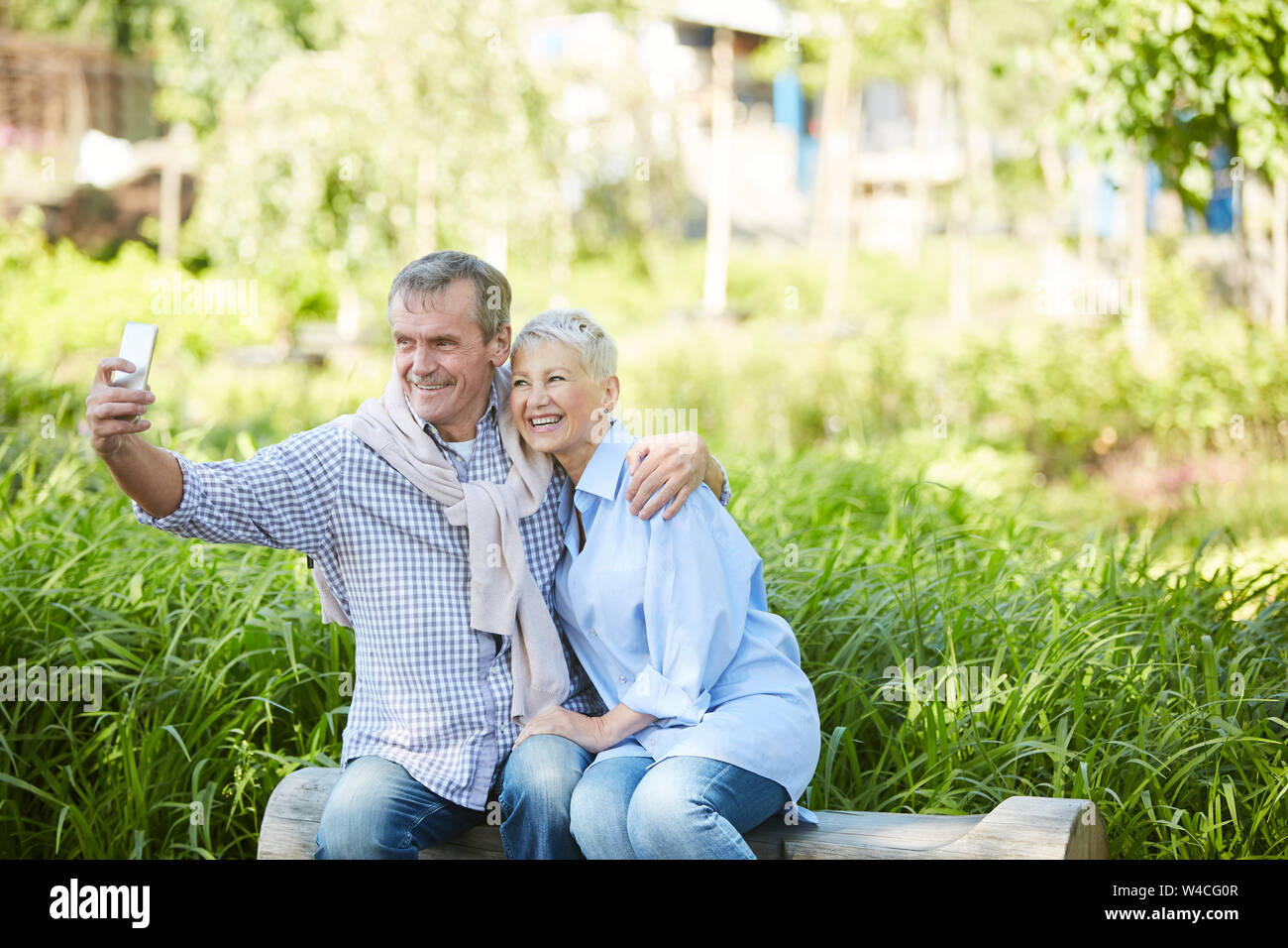Portrait de senior couple pose pour photo selfies tout en profitant de ce jour en parc, copy space Banque D'Images