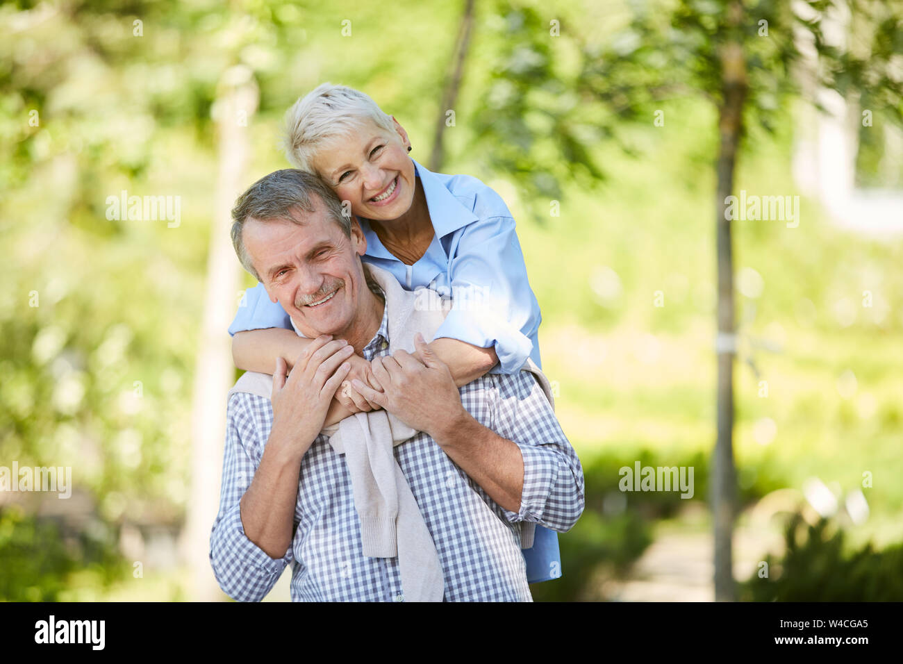 Portrait de senior couple smiling at camera while enjoying date l'extérieur en été, copy space Banque D'Images